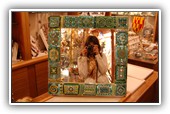 Green mirror:
Made of art glass, mirrored glass, murrine, gold and glass pearls on a wooden rounded base 
Size 50x50 cm border 8.5 cm. Also custom made.
